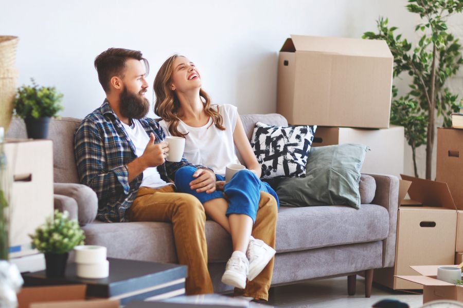 a happy young married couple moves to new apartment